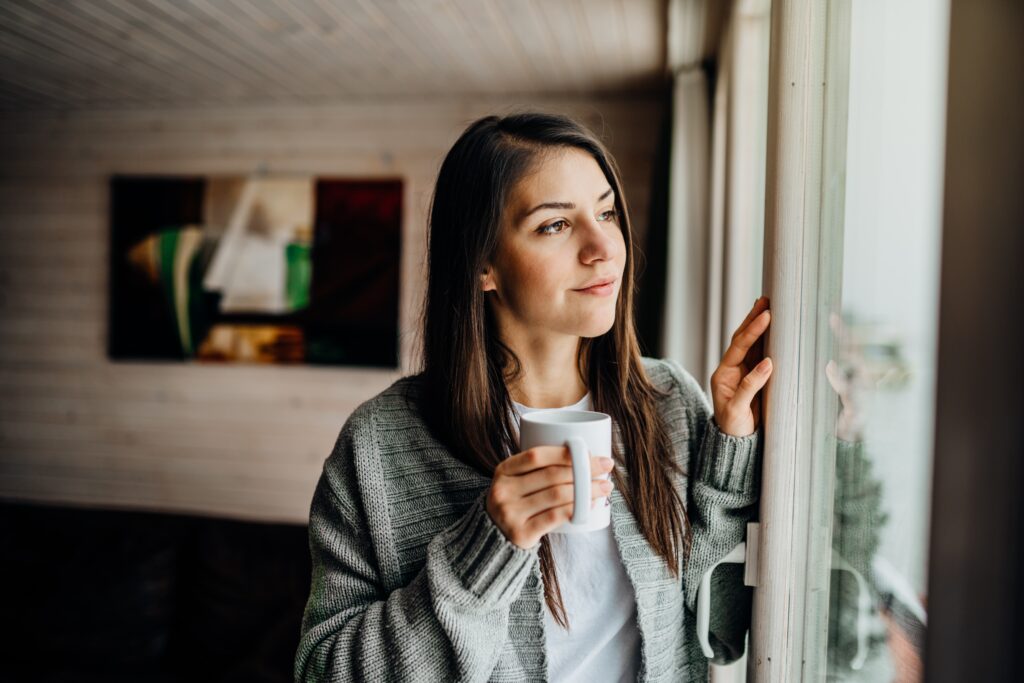 Woman in quarantine looking outside the window