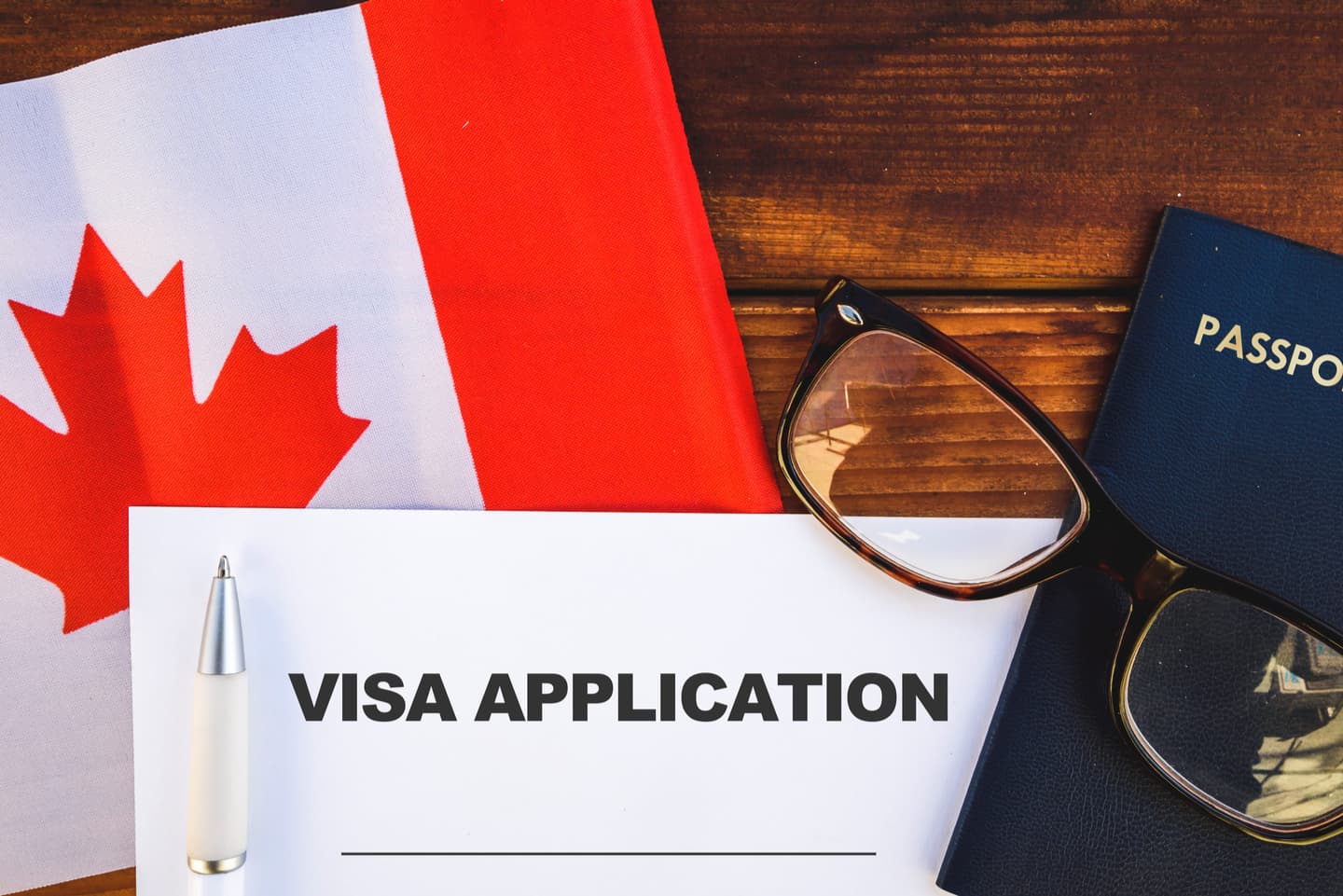 Visa application with Canadian flag and passport in background