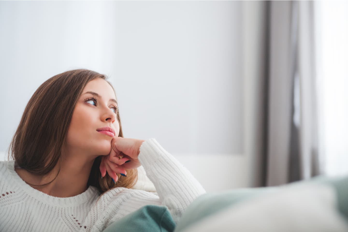 Young woman thinking on her couch